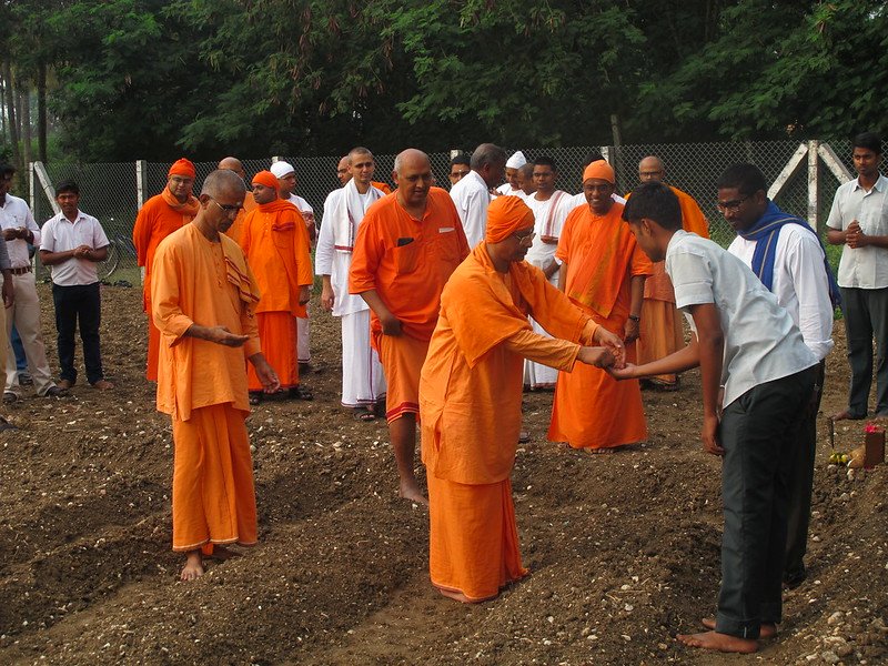 SRMV IARD monks and students participate in a traditional seed-sowing ceremony, blending spirituality with practical agriculture. logo
